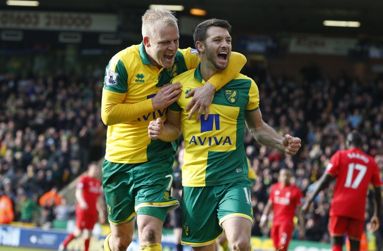 Hoolahan (D) celebra con Steven Naismith el gol del Norwich. Foto AFP/Parnaby