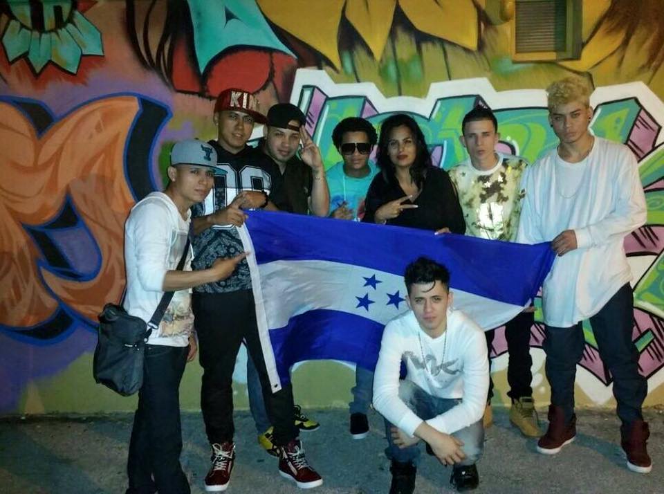 Por donde viaja, MR. JC suele posar con la bandera de Honduras. Aquí con amigos.