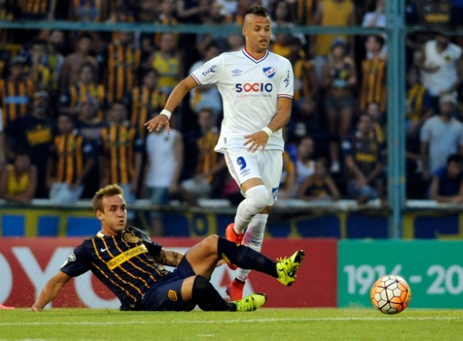 Gastón Gil Romero, de Rosario Central, intenta marcar a Nicolás López (#9), de Nacional. Foto AFP