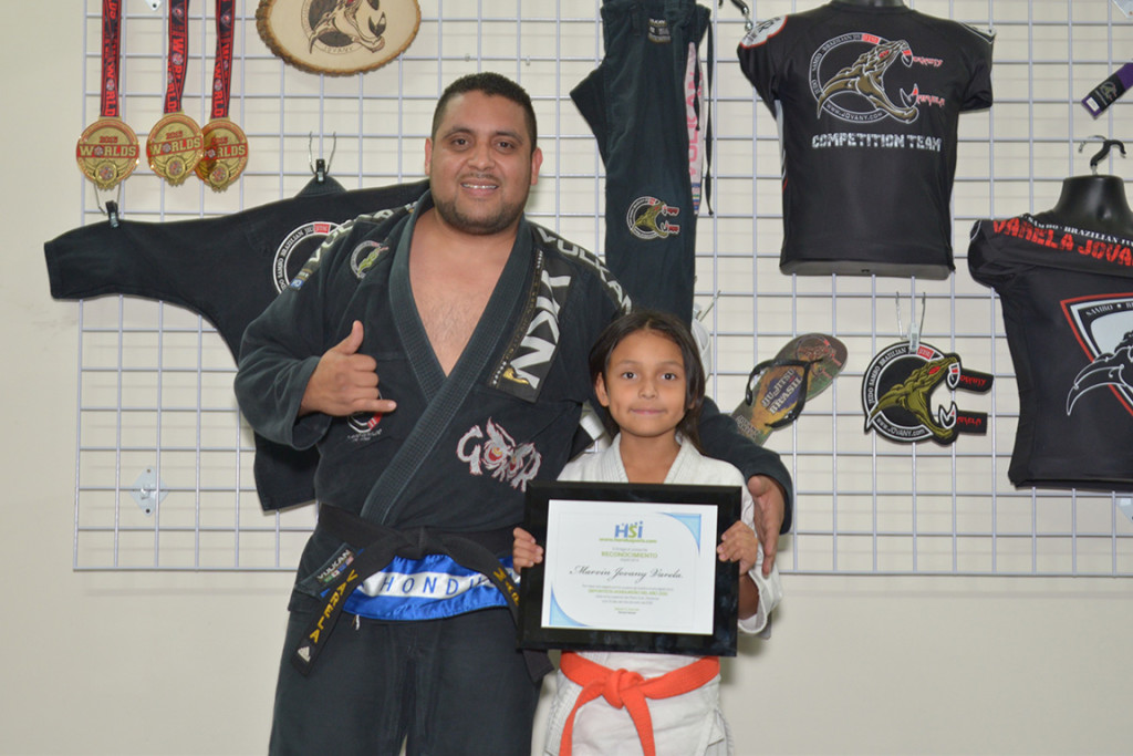 Marvin Varela con su hija muestran la placa de HonduSports. Foto HSI