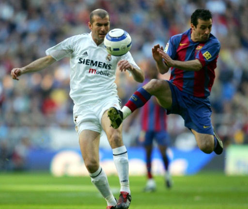 El francés Zinedine Zidane (I) lucha por el balón con su rival Ludovic Giuly (D) durante un partido entre el Real Madrid y el FC Barcelona, en el estadio Santiago Bernabéu, en Madrid, el 10 de abril de 2005