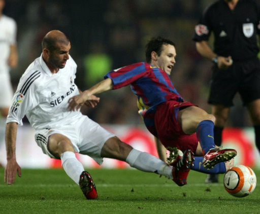 Zinedine Zidane (I) hace una entrada al barcelonista Andrés Iniesta (D) durante un partido de Liga entre el Real Madrid y el FC Barcelona, el 1 de abril de 2006 en el estadio Camp Nou, en Barcelona