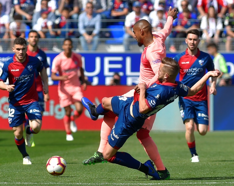 Jorge Pulido trata de quitar el balón al delantero visitante Kevin-Prince Boateng durante el partido liguero disputado entre Huesca y FC Barcelona