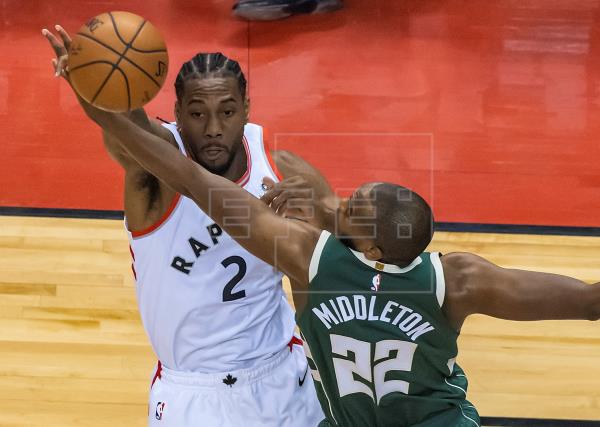Kawhi Leonard (i) de Toronto Raptors en acción ante Khris Middleton (d) de Milwaukee Bucks. Foto EFE