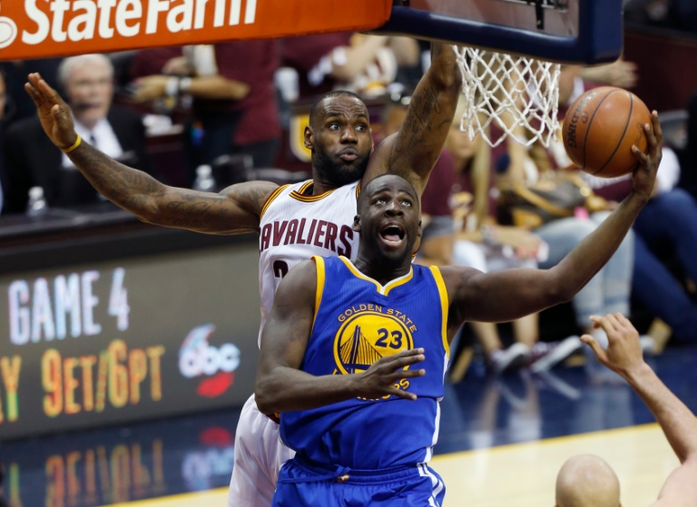 Draymond Green (D), de Golden State Warriors, penetra ante la marca de LeBron James (I), de Cleveland Cavaliers, en el tercer partido de la final de la NBA disputado Cleveland, Ohio, el 8 de junio de 2016 / AFP / Jay LaPrete