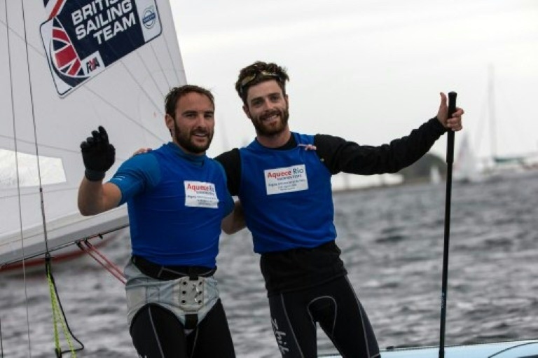 Los regatistas británicos Elliot Willis (i) y Luke Patience celebran su segunda plaza en una prueba internacional celebrada en Río de Janeiro el 9 de agosto de 2014 / AFP / Yasuyoshi Chiba