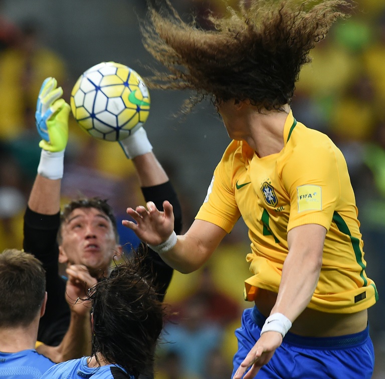 El arquero uruguayo Fernando Muslera (I) ataja un testarazo del brasileño David Luiz, en partido de eliminatoria sudamericana al Mundial de Rusia, el 25 de marzo de 2016, en Recife / AFP / Vanderlei Almeida