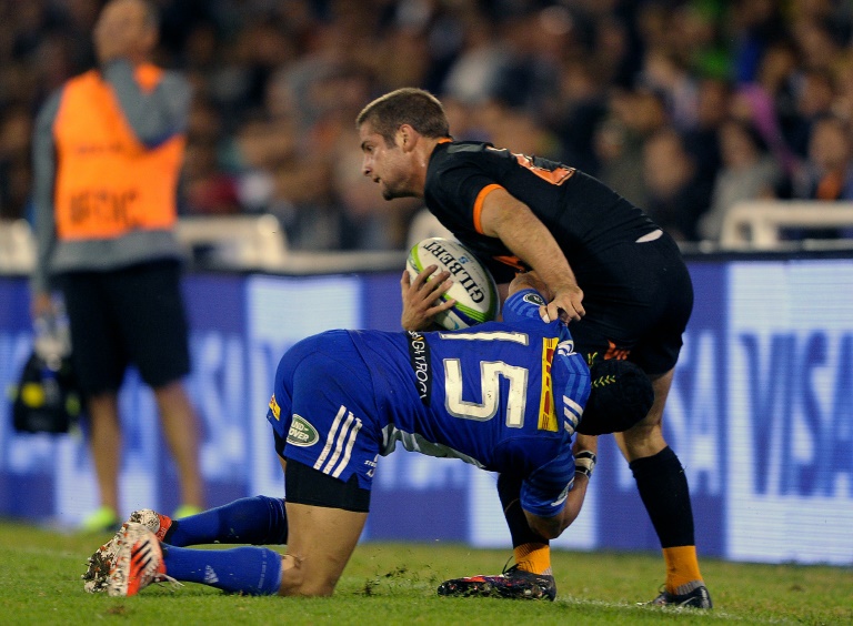 El fullback del argentino Jaguares Santiago Cordero (R) es interceptado por eñ bacl deñ sudafricano Stormers Cheslin Kolbe durante su partido del torneo Súper Rugby en el estadio José Amalfitani en Buenos Aires, Argentina, el 26 de marzo de 2016. / AFP / ALEJANDRO PAGNI