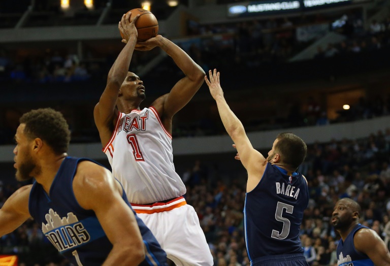 El ala-pivot Chris Bosh (1) de Miami Heat tira al aro ante la marca del puertorriqueño J.J. Barea (5) de Dallas Mavericks, en partido de la NBA jugado en el American Airlines Center, en Dallas, el 3 de febrero de 2016 / AFP / RONALD MARTINEZ